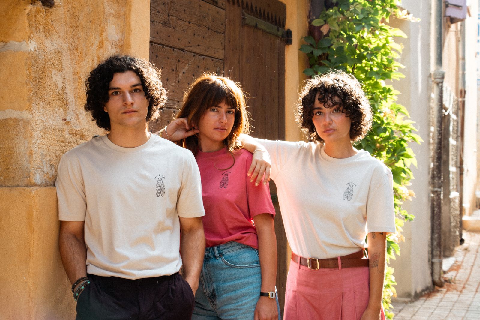 Trois personnes portant les t-shirts cigale Amor et Cigale dans une ruelle du Sud